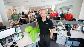 CEO’s space is like everyone else’s at C1 Bank. Green dog statues, bought as a toy for Trevor Burgess’s young daughter, are now in every location.
